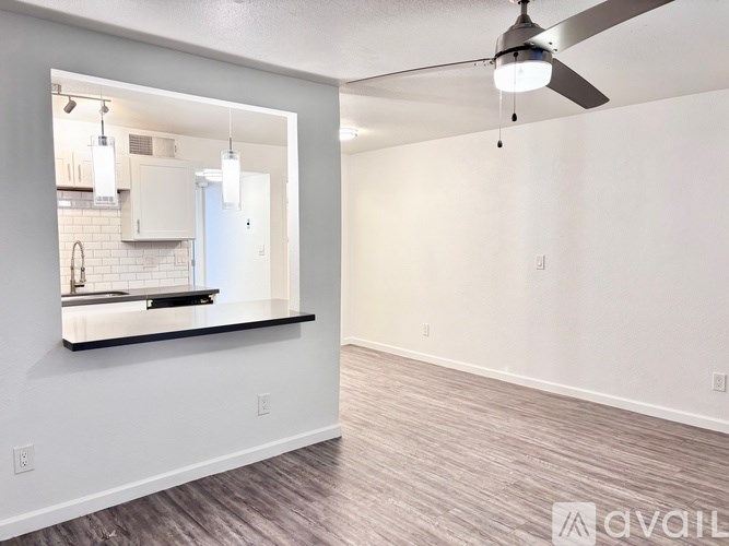A room with a ceiling fan and a mirror on the wall.
