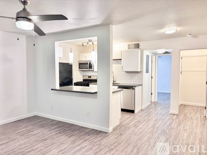 A spacious kitchen with a ceiling fan and a view of the outdoors.