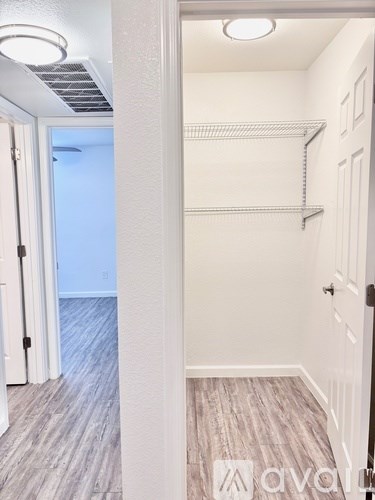 A hallway with a white door and a white wall.