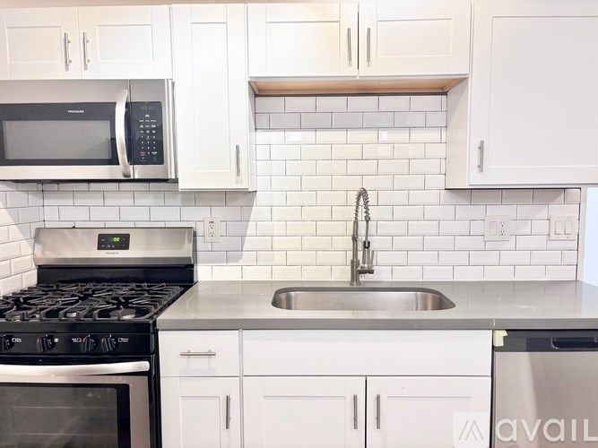 A kitchen with a stove, microwave, and sink.