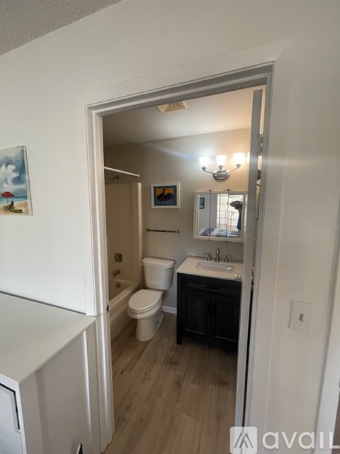 A bathroom with a toilet, sink, and a mirror.