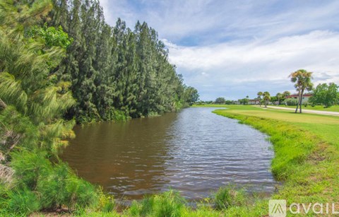 A river flows through a lush green landscape with trees on both sides.