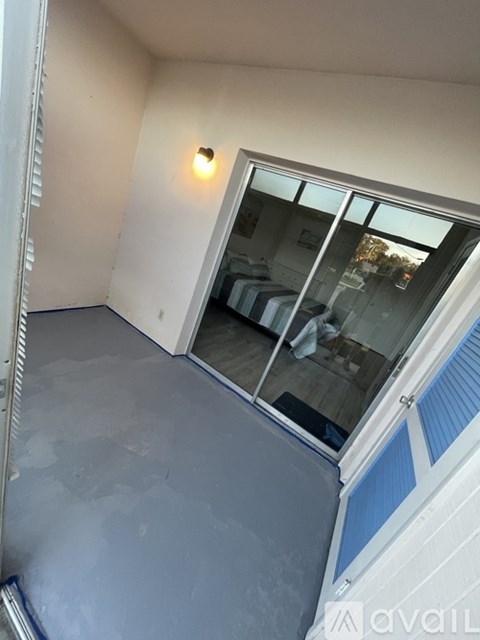 A room with a window and a wall light.