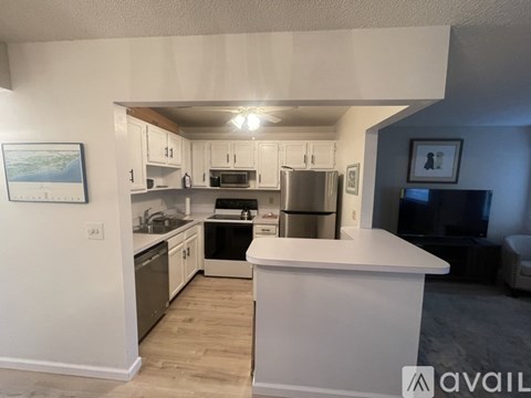 A kitchen with white cabinets and a white island.