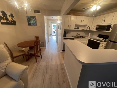 A kitchen with a dining table and chairs.