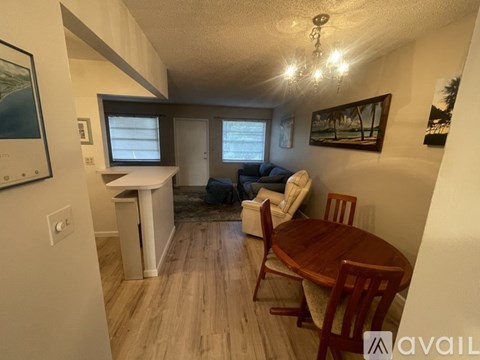 A living room with a couch, chairs, and a dining table.