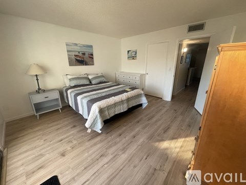 A bedroom with a bed, nightstand, and lamp.