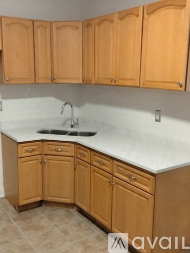 A kitchen with wooden cabinets and a marble countertop.