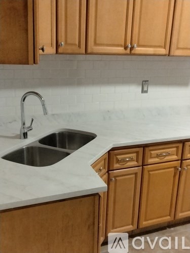 A kitchen with wooden cabinets and a marble countertop.