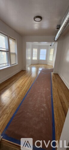 A room with wooden flooring and white walls.