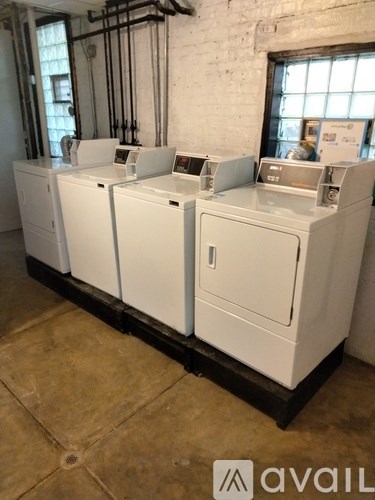 A row of white washing machines are lined up in a room.