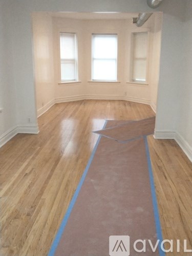 A room with wooden flooring and a blue line down the middle.