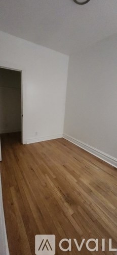 A room with wooden flooring and white walls.