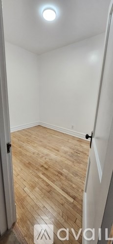 A room with wooden flooring and white walls.