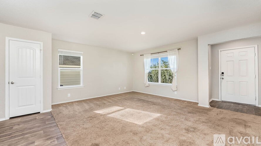 A room with white walls and a window with blinds.