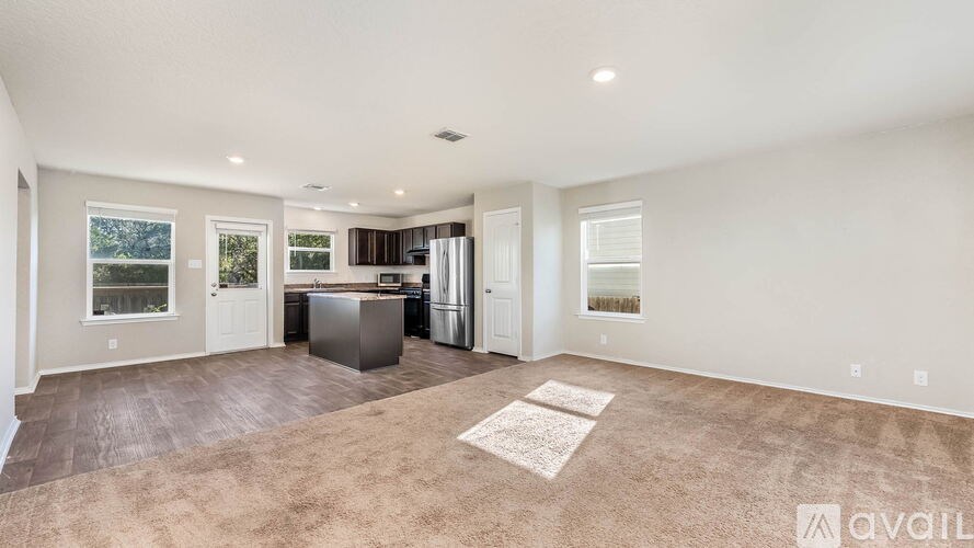 A spacious kitchen and living room with a large island in the middle.