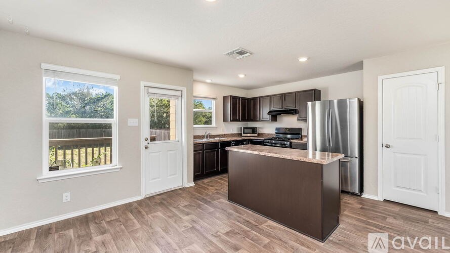 A kitchen with a brown island and white cabinets.