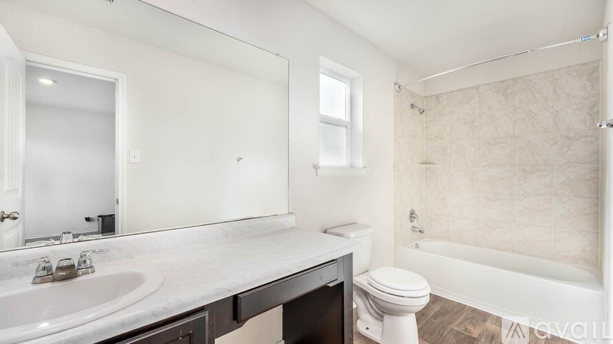 A white bathroom with a sink, toilet, and bathtub.