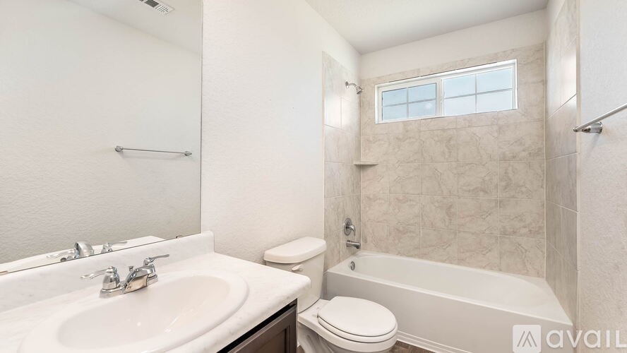 A bathroom with a white sink, toilet, and bathtub.