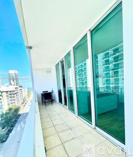 A balcony with glass doors overlooking a cityscape.