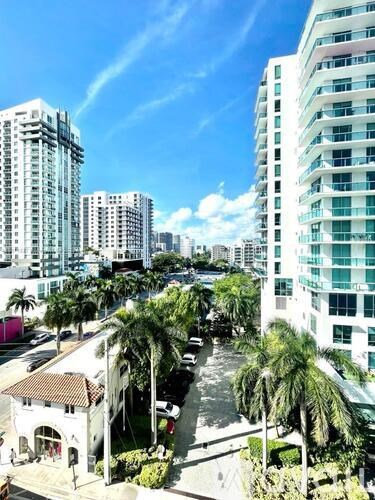 A view of a city with tall buildings and palm trees.