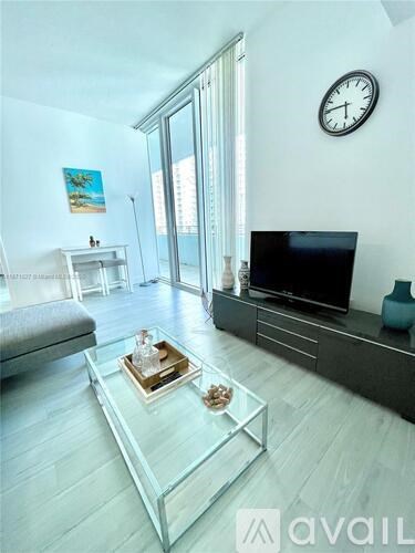 A living room with a glass coffee table in the center.