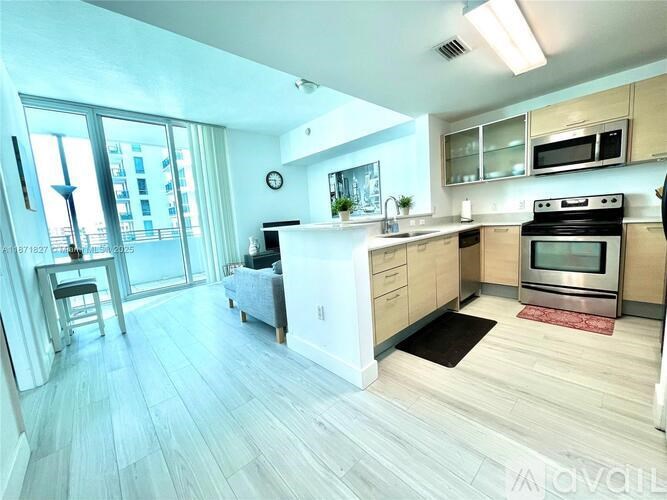 A modern kitchen with a large island and stainless steel appliances.