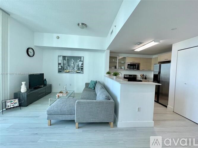 A living room with a grey couch and a television.