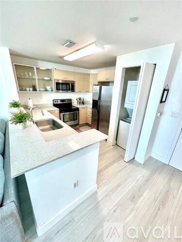 A kitchen with white cabinets and a white countertop.
