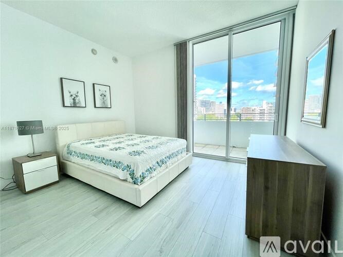 A bedroom with a large bed, a nightstand, and a wooden cabinet.