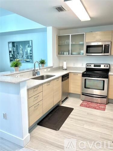 A kitchen with a sink, stove, and oven.