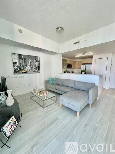A living room with a grey couch and a coffee table.