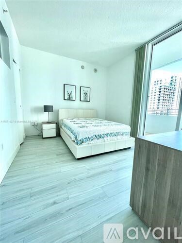 A bedroom with a bed, nightstand, and lamp.