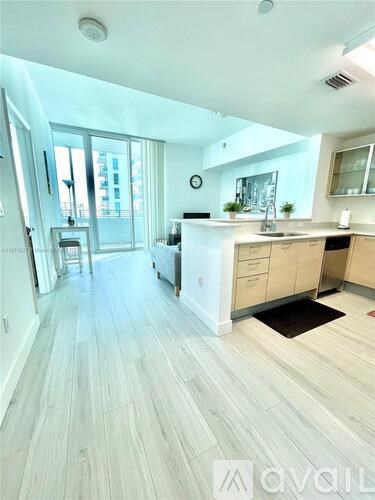 A modern kitchen with wooden floors and a large island.