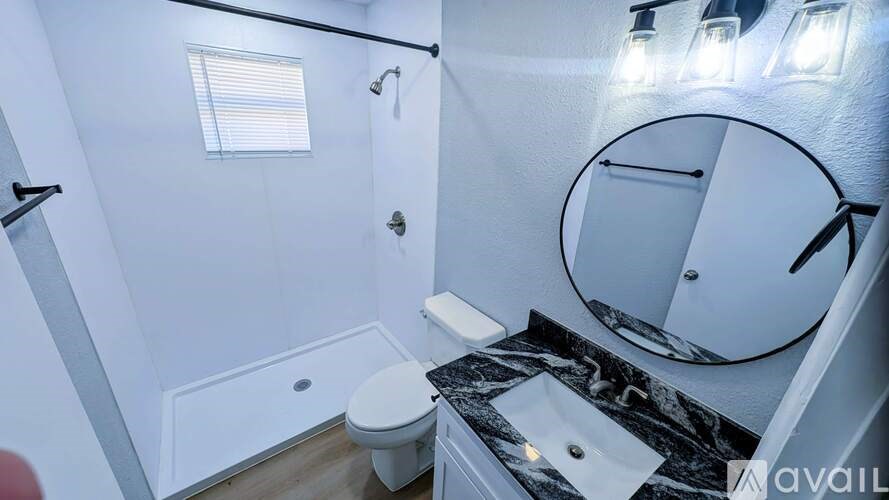 A bathroom with a toilet, sink, and mirror.