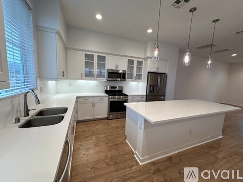A modern kitchen with white cabinets and a large island.