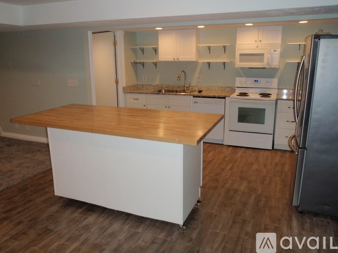 A kitchen with a wooden island in the middle.