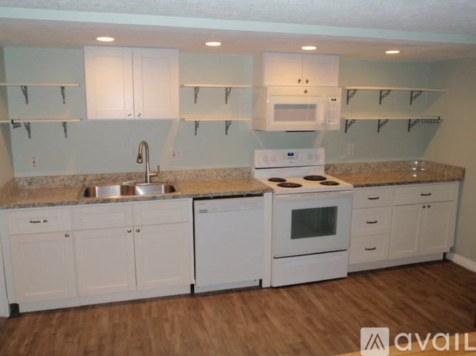 A kitchen with white cabinets and a granite countertop.