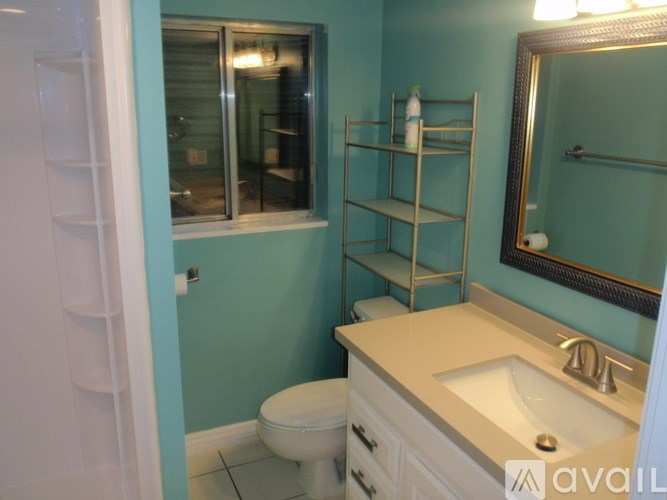 A bathroom with a toilet, sink, and mirror.