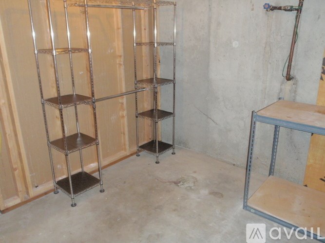 A room with a concrete wall and a metal shelving unit.