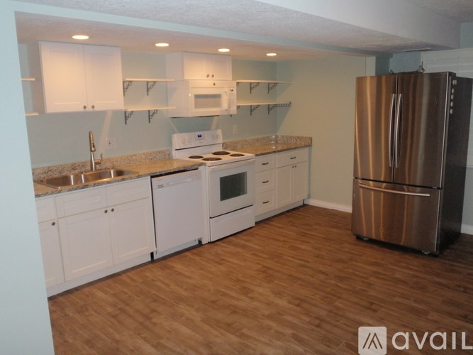 A kitchen with white cabinets and a stainless steel refrigerator.