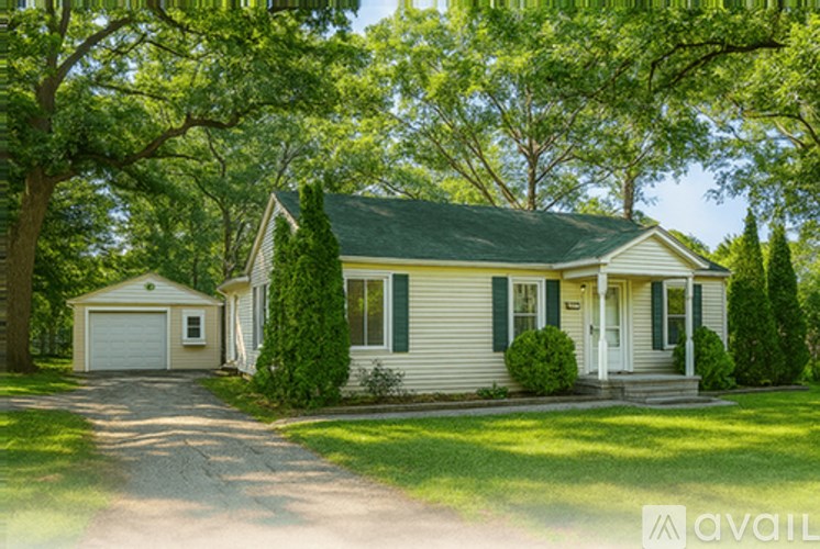 A house with a green roof and white walls is surrounded by trees.