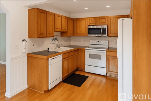 A kitchen with wooden cabinets and white appliances.
