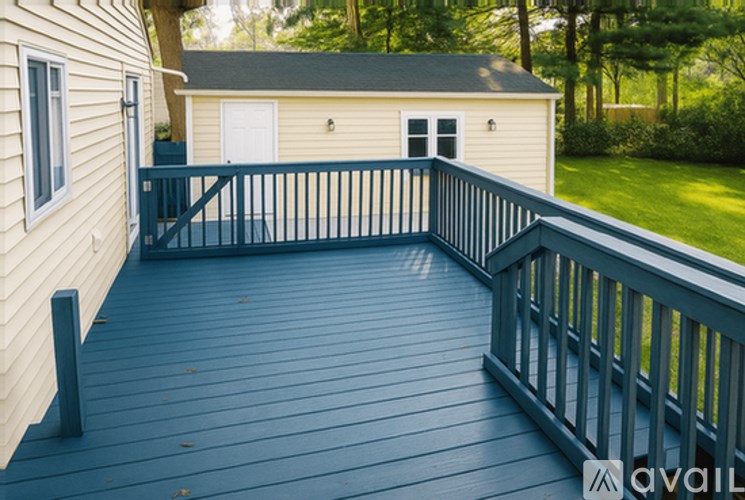 A deck with a railing and a house in the background.