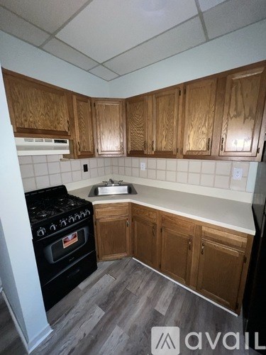 A kitchen with wooden cabinets and a black stove top oven.