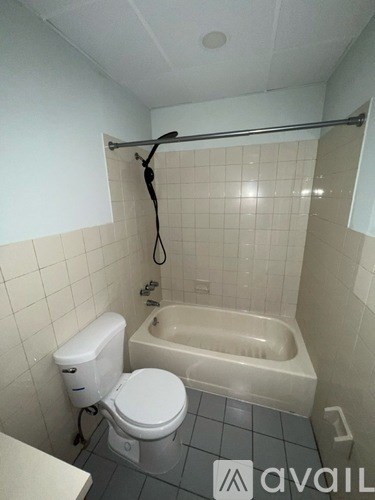 A white toilet is next to a bathtub in a bathroom.
