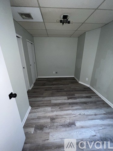 A room with a wooden floor and a white door.