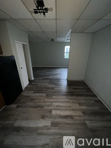 A room with wooden flooring and white walls.