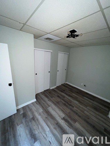 A room with a ceiling fan and wood flooring.