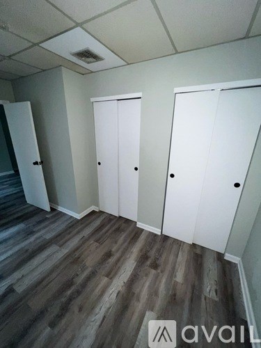 A room with three white doors and a wooden floor.